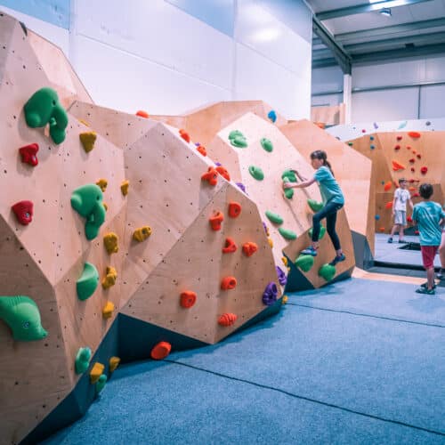 A group of children climbing on a bouldering wall at Flaspoint.