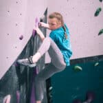A young girl bouldering on a wall at Flashpoint Cardiff.