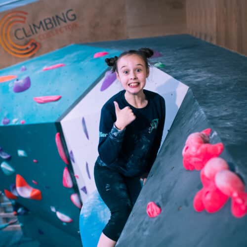 A girl climbing on an indoor climbing wall in Cardiff.